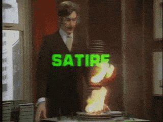 An model of a building on fire with the word SATIRE in bright green flashing on top of it